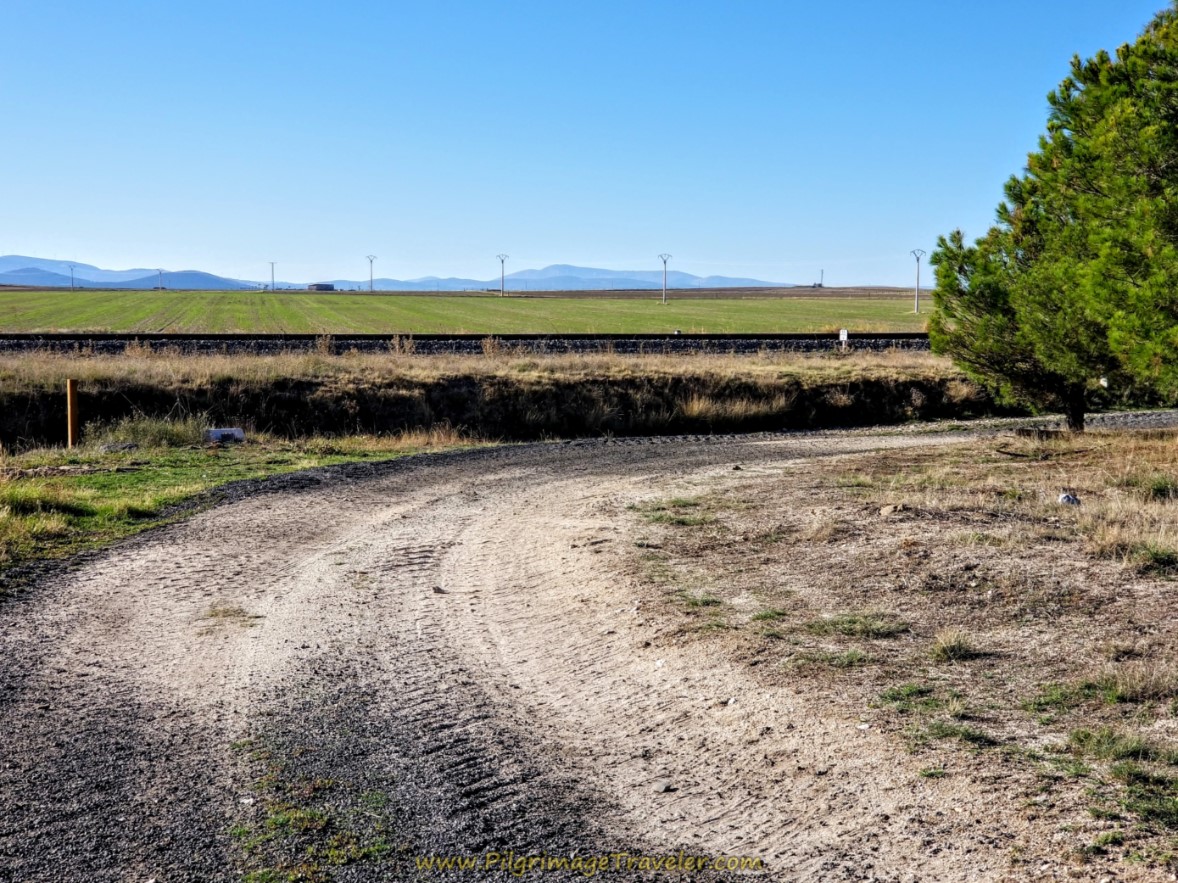 Bend in Road Joins Railroad Tracks