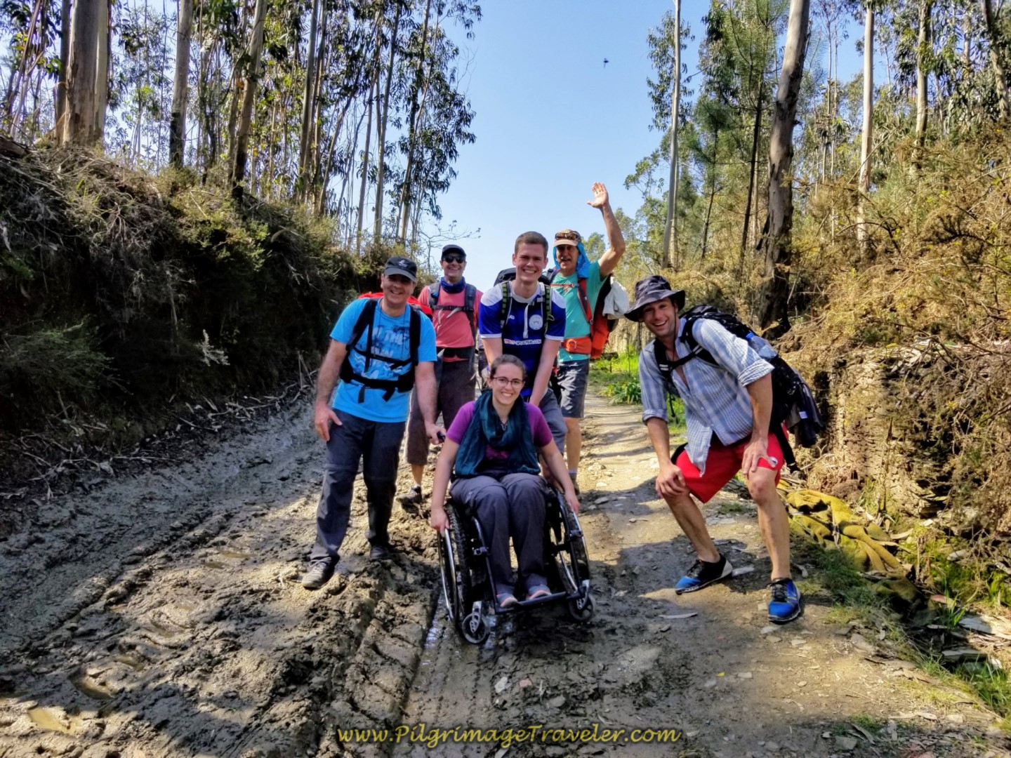 The Magdalena Mud Team guides the wheelchair through the mud and ruts on the Rua Caminho de Santiago on day sixteen of the Central Route of the Portuguese Way
