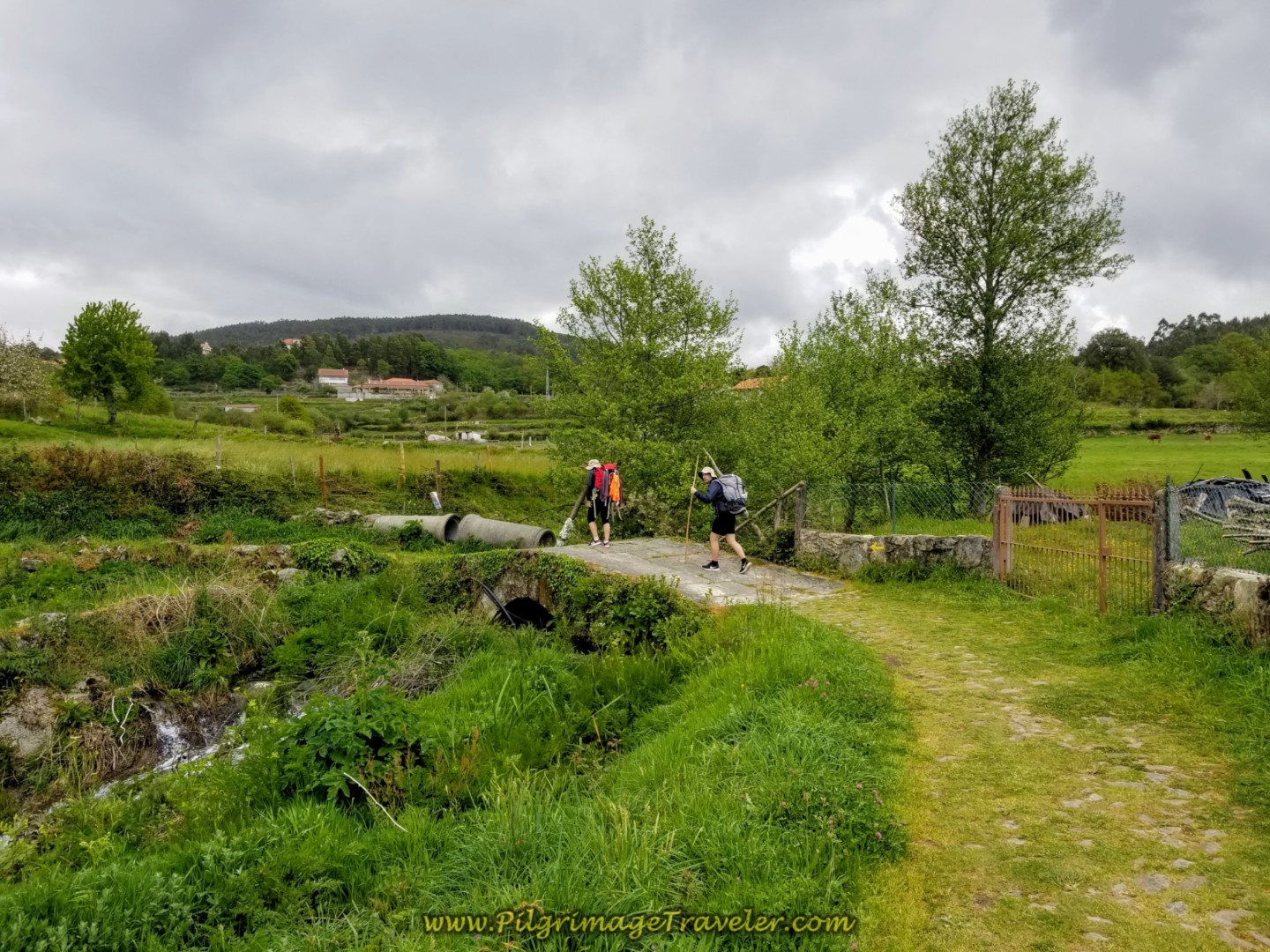 Peregrinos Crossing Small Roman Bridge on day eighteen on the Central Route of the Portuguese Camino